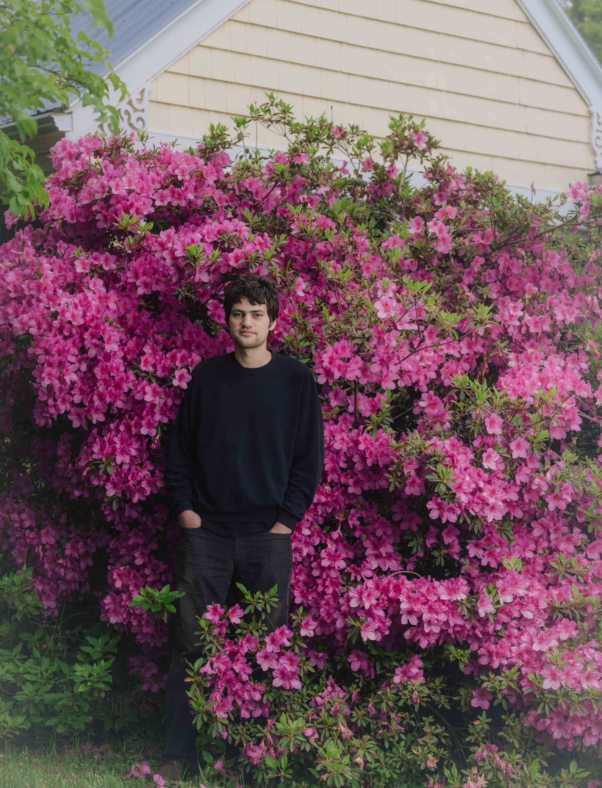 Den amerikanske artisten MJ Lenderman står blant blomster