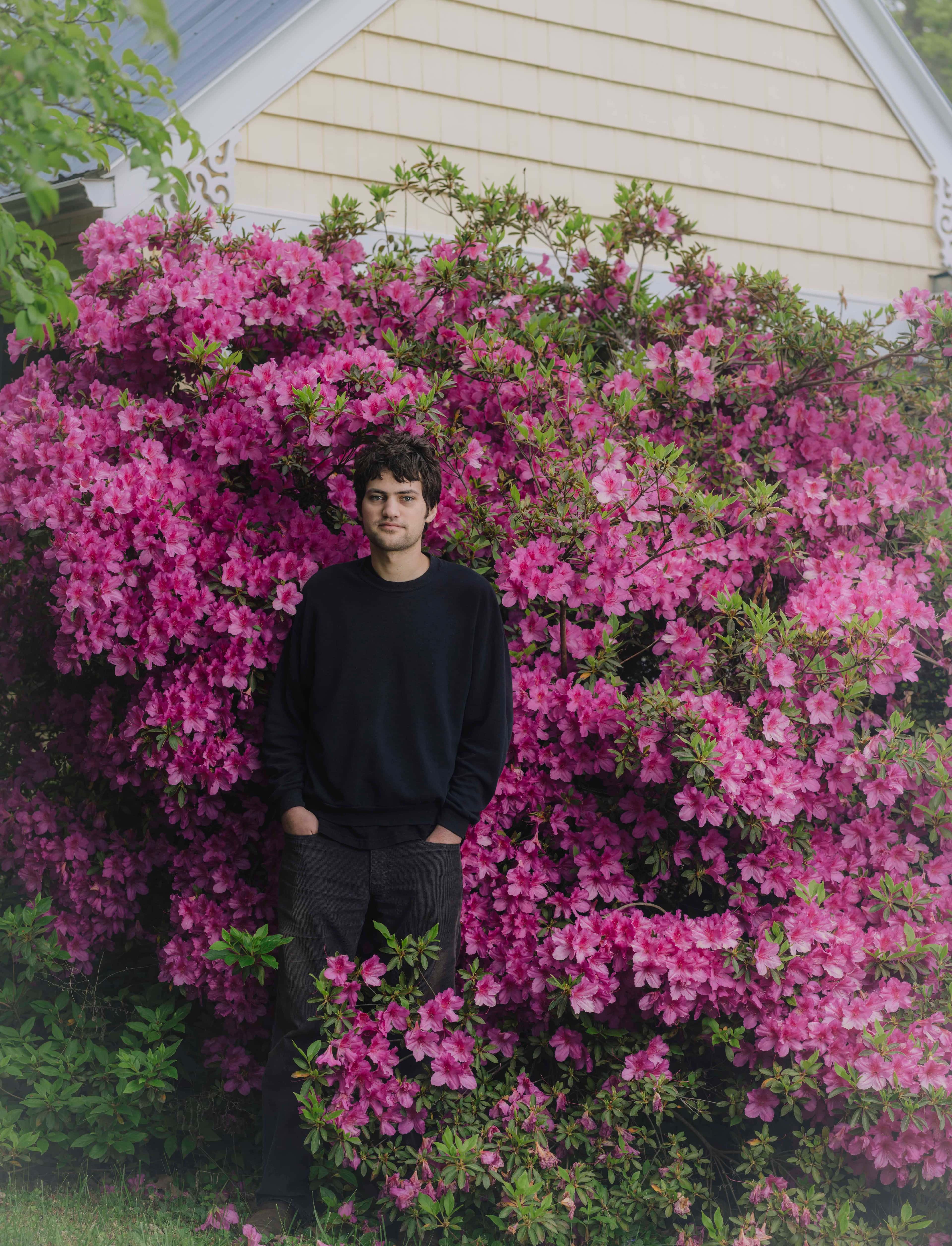 Den amerikanske artisten MJ Lenderman står blant blomster