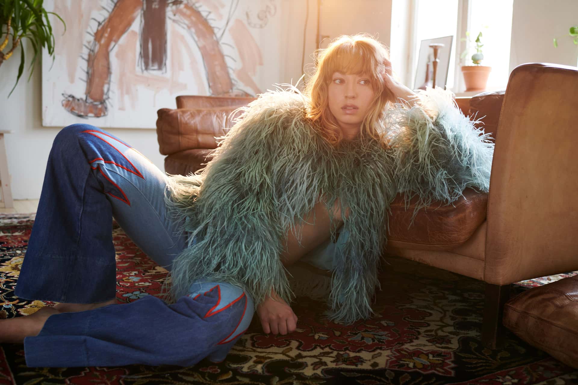 Den norske artisten Rabo lener seg mot en sofa