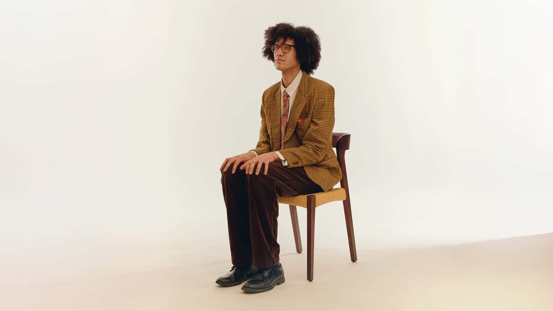 Den norske artisten Beharie sitter på en stol midt i rommet