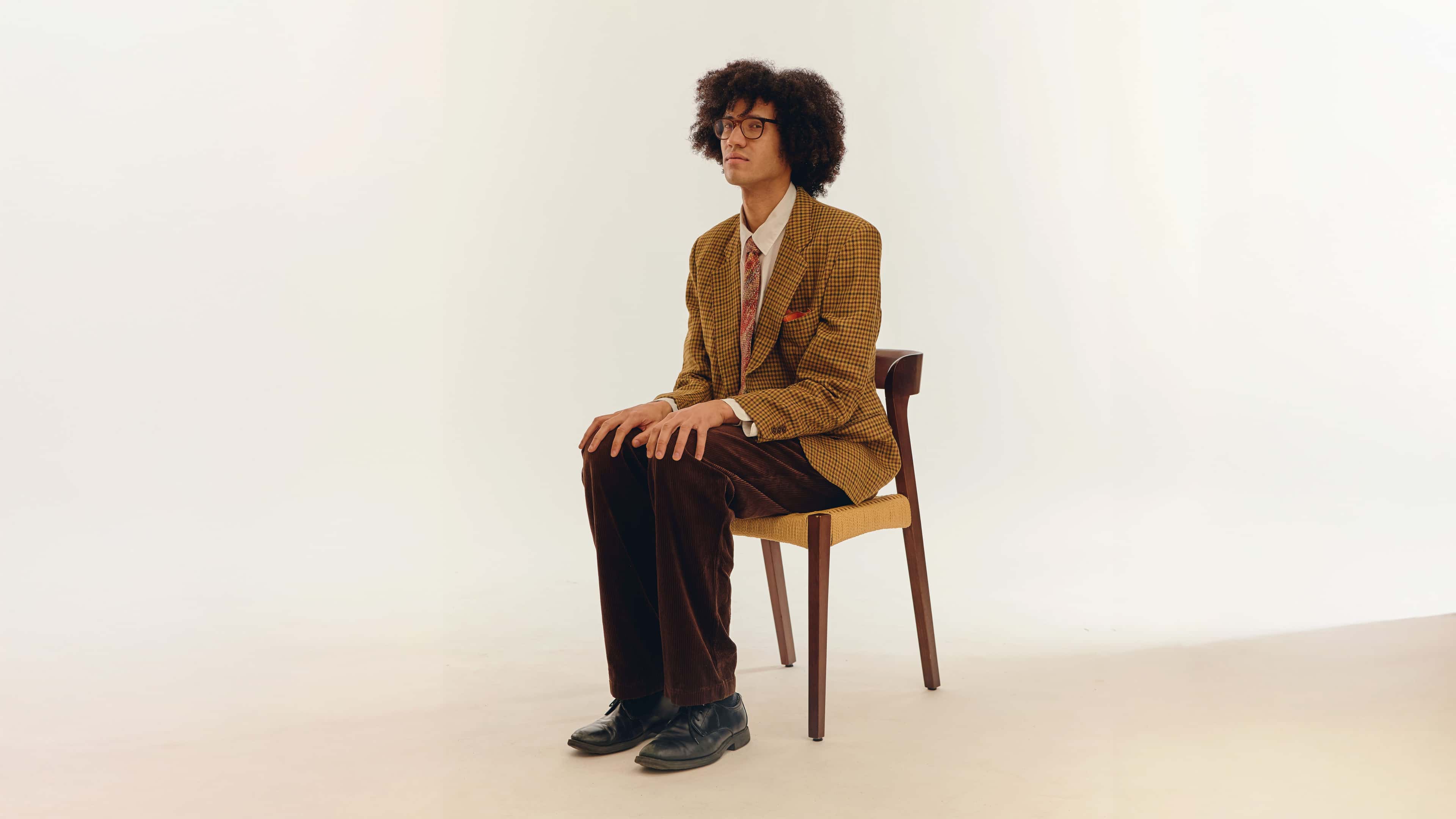 Den norske artisten Beharie sitter på en stol midt i rommet