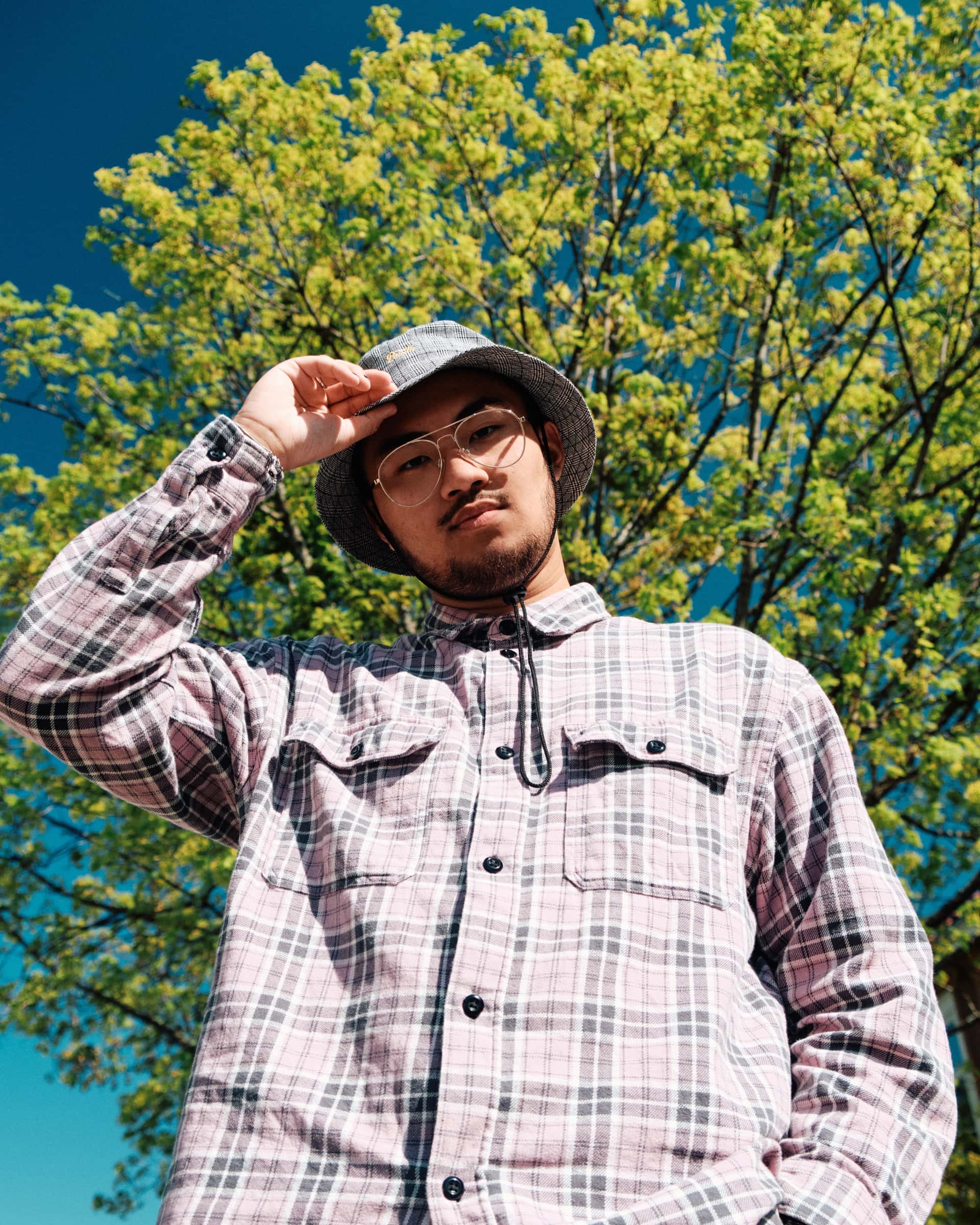 Den norske artisten AAvery i sola, foran et tre