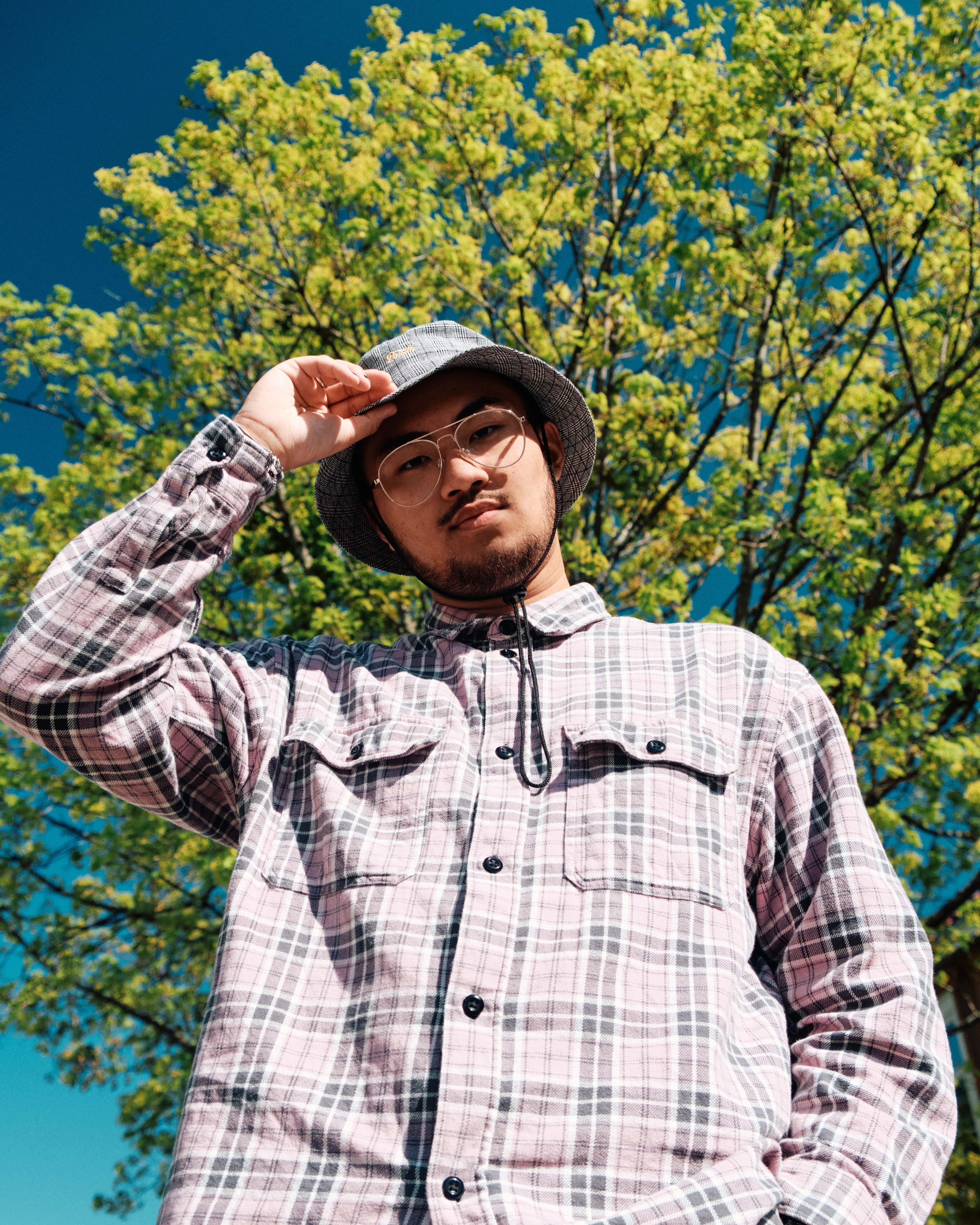 Den norske artisten AAvery i sola, foran et tre