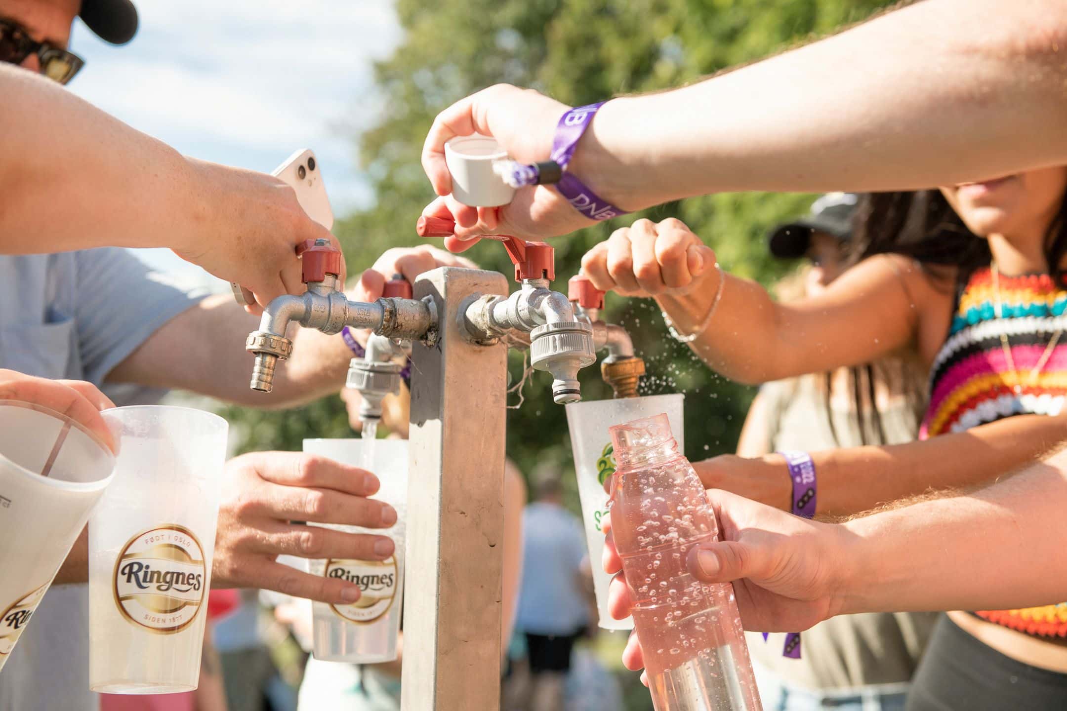 Publikum fyller gjenbruksglass med vann