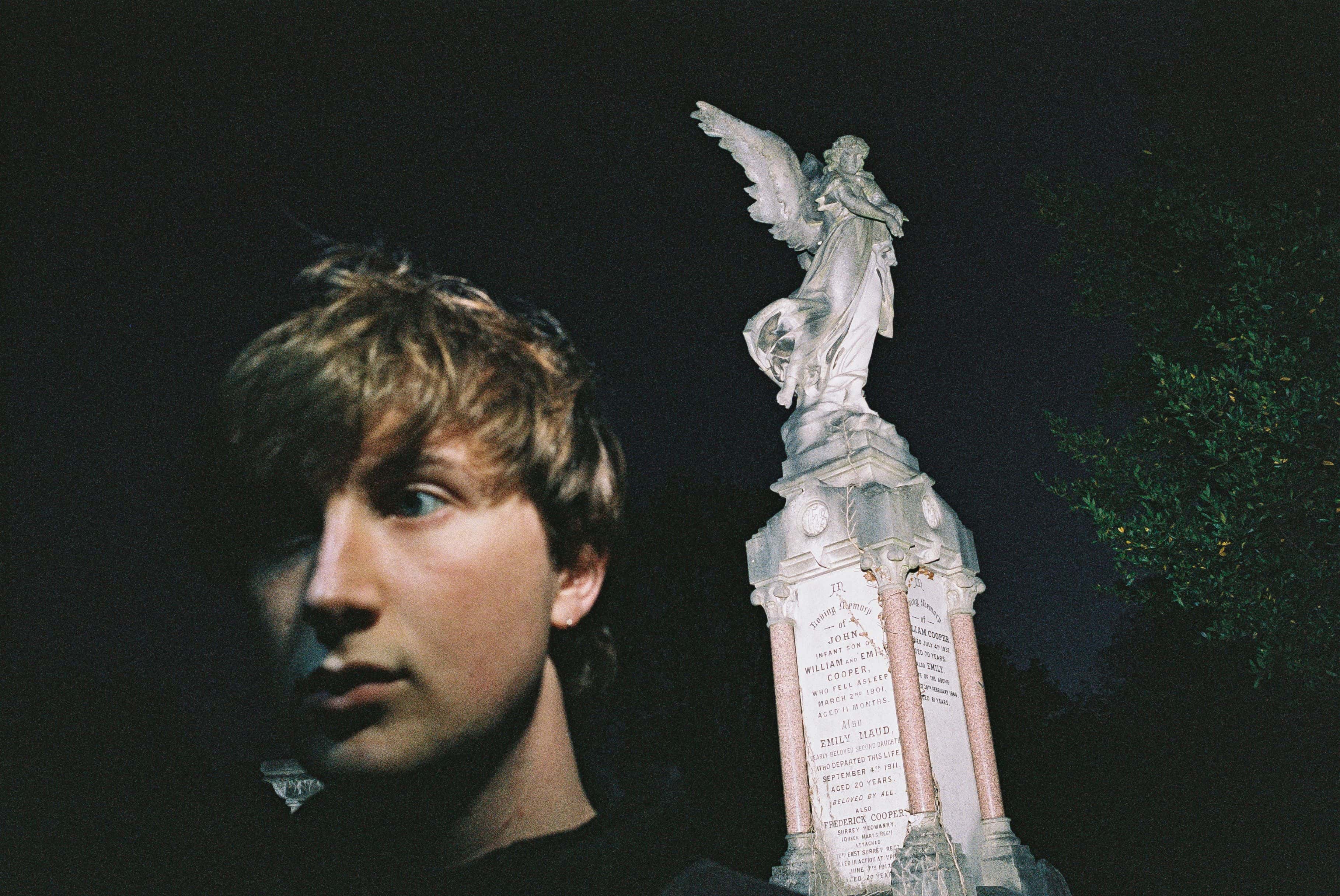 Den irske artisten Dove Ellis foran en statue om natta