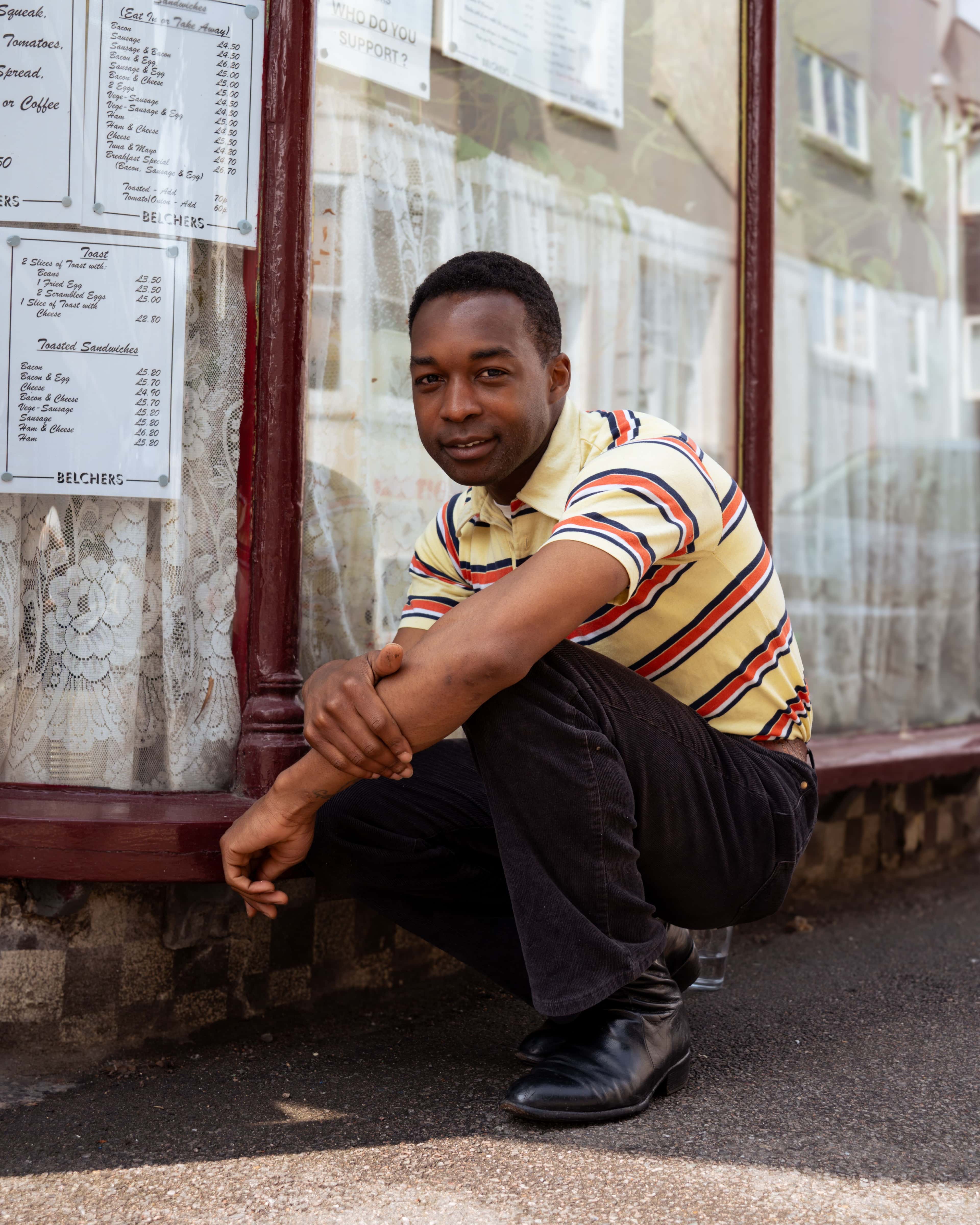 Jalen Ngonda sitter på huk utenfor en restaurant