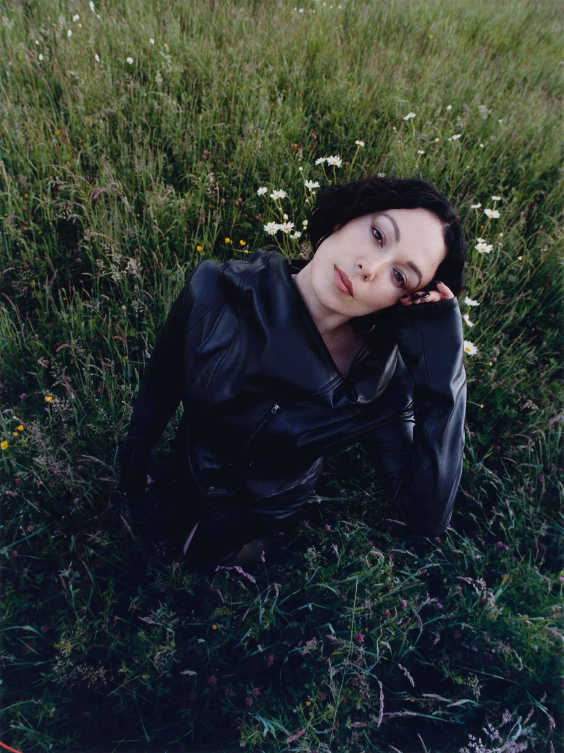 Den britiske artisten Kelly Lee Owens i en grønn eng