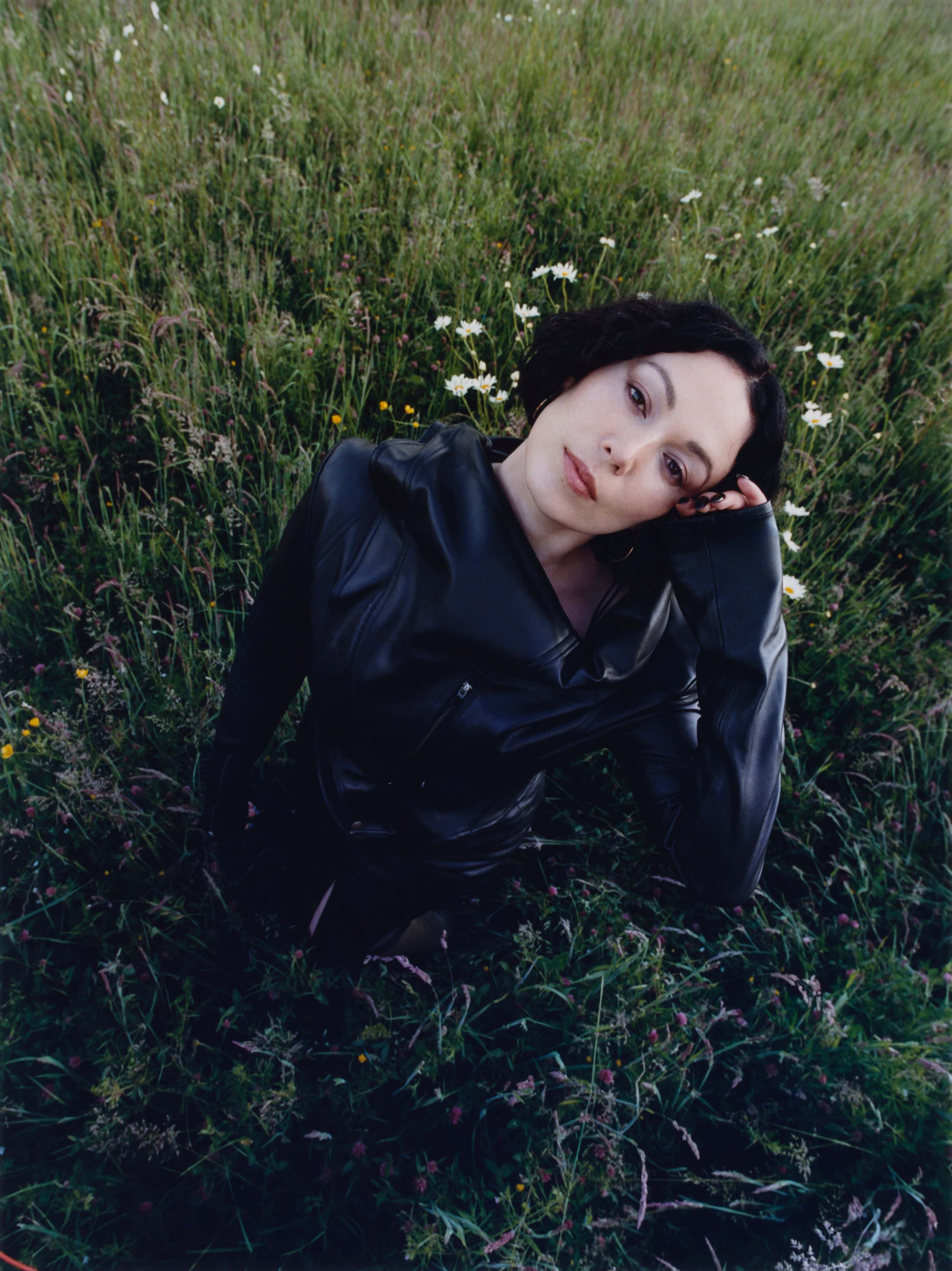 Den britiske artisten Kelly Lee Owens i en grønn eng